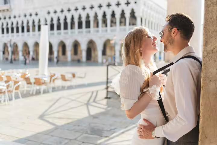 Couple embracing near St Mark’s Square arches, Venice Italy wedding photography tour with candid portraits