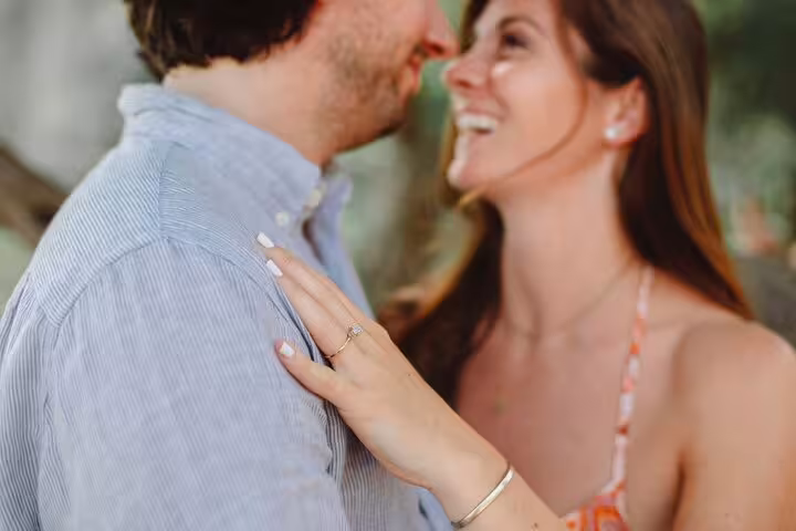Close-up of a couple sharing a joyful moment, highlighting an engagement ring, ideal for a Naples photoshoot.