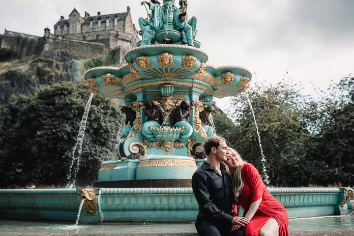 Couple in front of a vibrant fountain with Edinburgh Castle in the background, ideal for a romantic photoshoot.