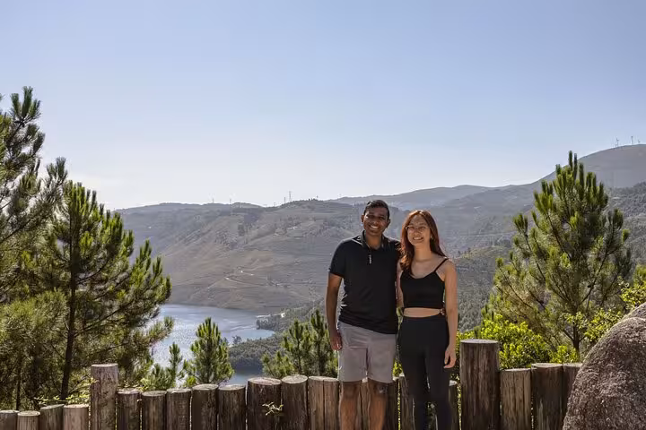 Happy couple posing with breathtaking panoramic views of Geres National Park's rolling hills and serene waters.