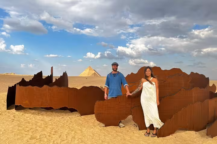 Couple posing at desert art installation near Giza Pyramids on hidden gems skip-the-line tour with epic pics