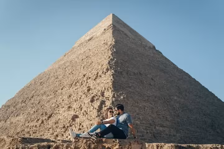 Couple relaxing by the Great Pyramid of Giza during ultimate 3-day Cairo pyramids and museum tour