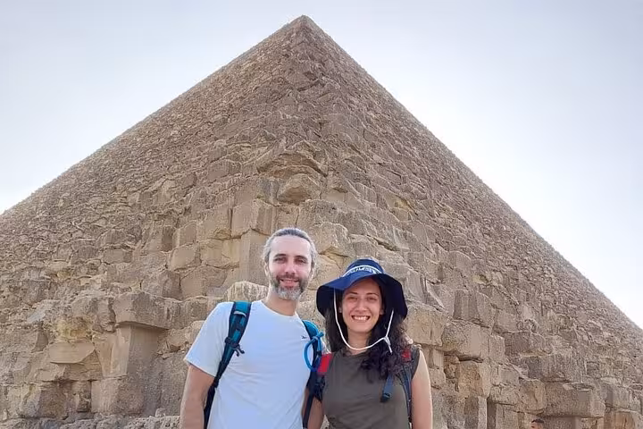 Couple posing at the Great Pyramid of Giza on a 3-day Cairo tour with pyramids, museums and churches