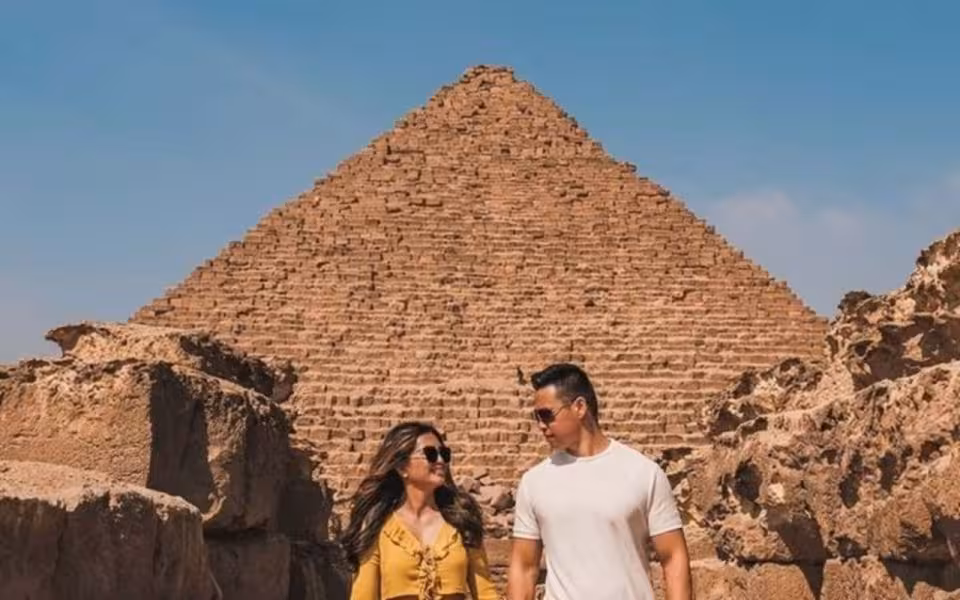 Couple walking near the Great Pyramid of Giza during Cairo pyramids tour with camel ride and lunch
