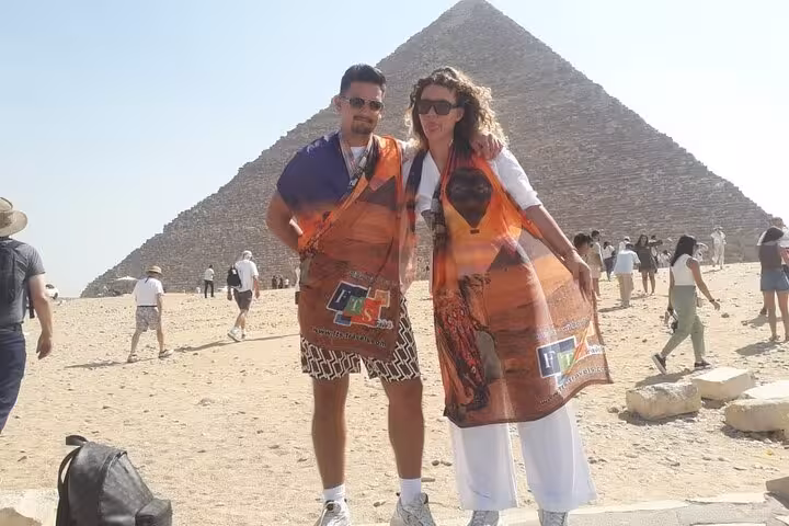 Couple posing at the Great Pyramid of Giza on Hurghada to Cairo day trip with Grand Egyptian Museum visit