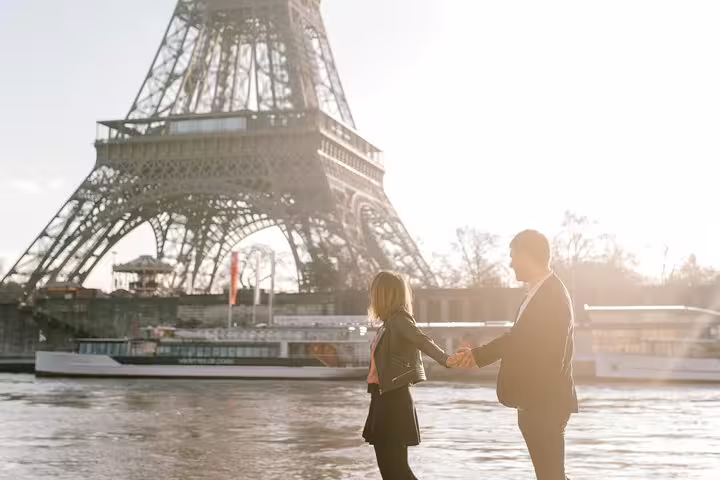 Couple holding hands by the Seine with Eiffel Tower backdrop, Paris proposal photographer at golden hour