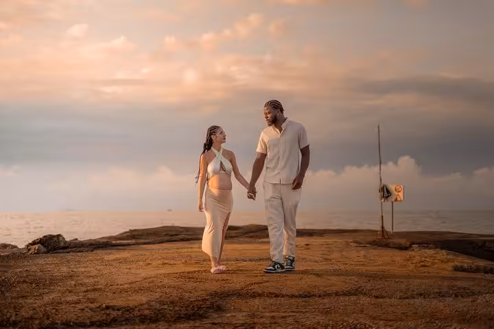 Couple holding hands on a picturesque dock in Analipsi during a sunset photoshoot, capturing romantic moments.