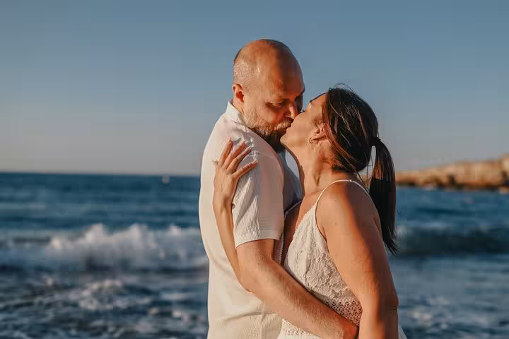 Couple sharing an intimate embrace by the sea during a private photoshoot in Hersonissos.