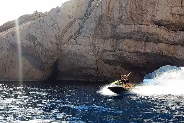 Couple on jet ski near Ibiza sea cave on San Antonio to Margaritas Islands guided tour route