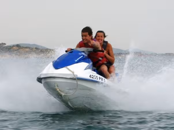 Couple experiencing an exhilarating jet ski ride on open waters, ideal for adventurous couples seeking thrilling activities.