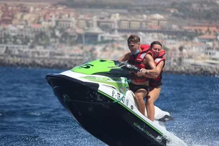 Adventurous couple enjoying a thrilling jet ski ride with splashy waves on a scenic 1-hour safari tour.
