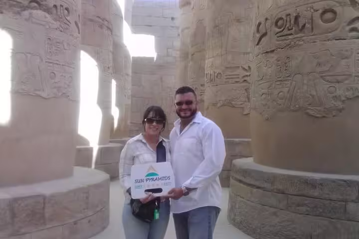 Couple posing among Karnak Temple columns in Luxor on a private Hurghada to Luxor day tour by car