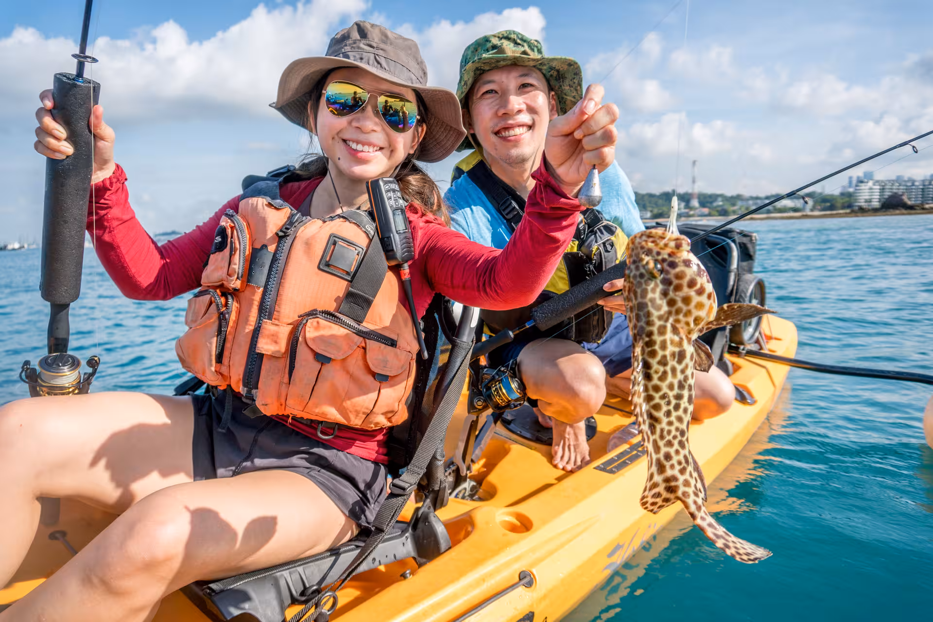 Smiling couple kayak fishing and holding catch on Saint John Island tour.