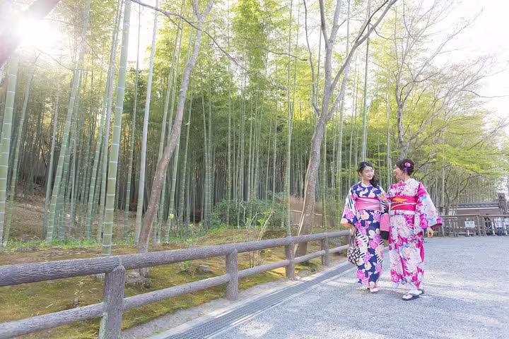 Couple in colorful kimono walking in Arashiyama bamboo grove, Kyoto, during private vacation photo shoot