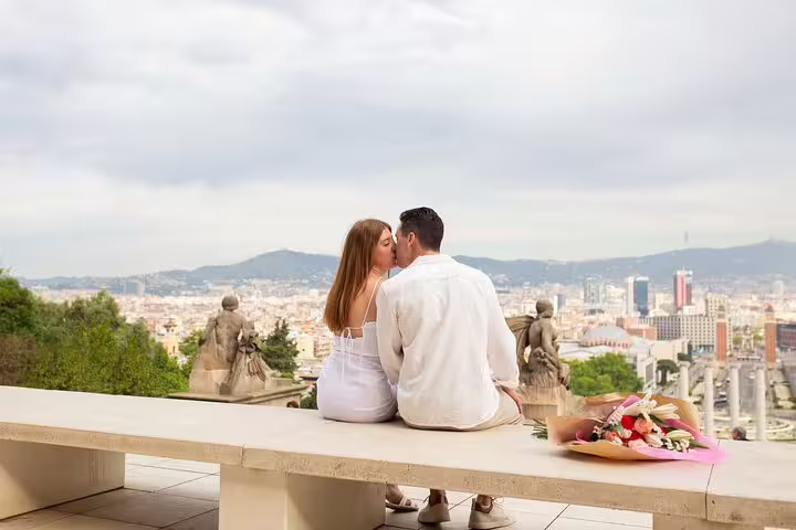 Couple kissing at Montjuïc viewpoint Barcelona with bouquet, romantic proposal photographer session