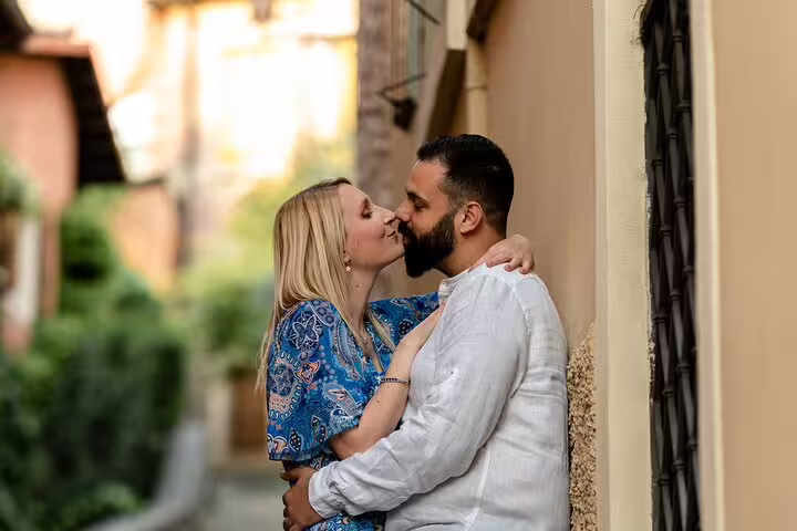 Couple kissing in charming alley during Verona photoshoot, capturing romantic moments in Italy's historic city.