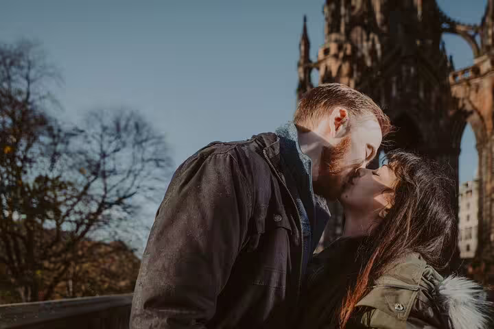Couple kissing near Scott Monument in Edinburgh, captured during a private photoshoot with a professional photographer