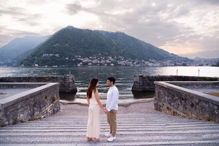 Couple holding hands on lakefront steps in Lake Como, captured on a private travel photographer tour