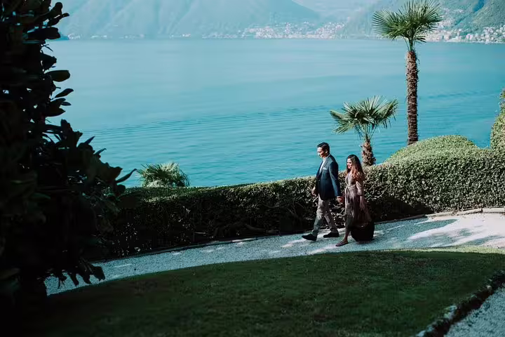 Couple strolling a lakeside garden path with Lake Como views, shot on a private tour with personal photographer