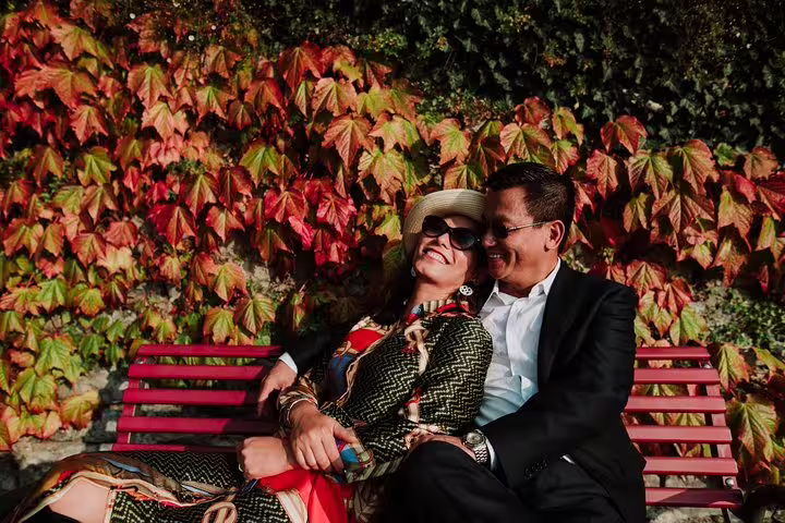 Couple cuddling on a bench with autumn vines, captured on a private Lake Como travel photographer tour