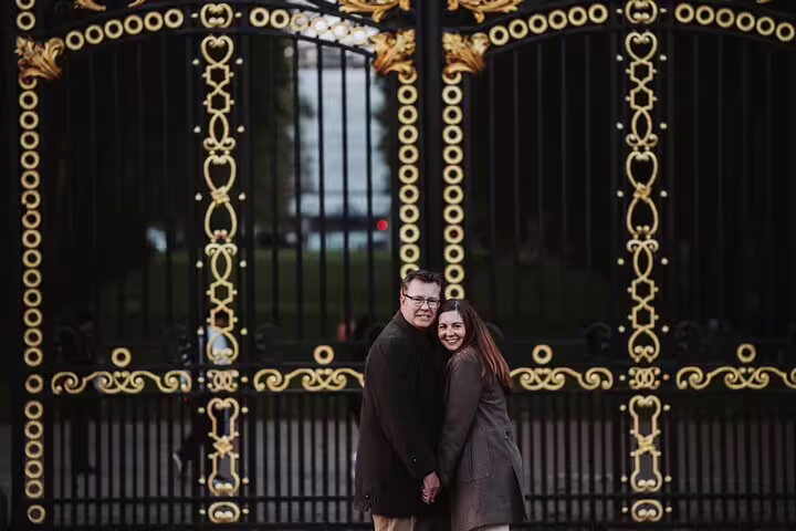 Couple posing in front of ornate gates in London on a personal travel photographer tour.