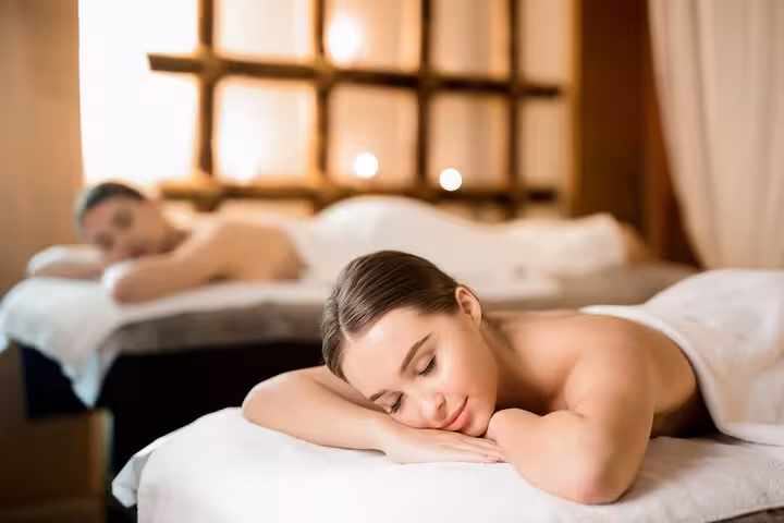 Couple relaxing on spa beds during 2-hour Luxor hammam experience with soothing massage and warm ambiance