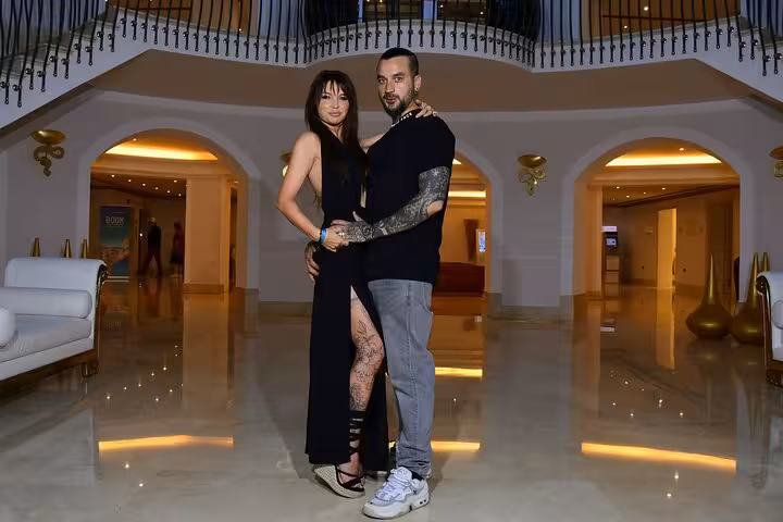 Couple posing elegantly in a luxurious hotel lobby during a private photoshoot experience in Malia.