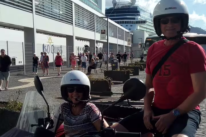 Couple enjoys Madeira Scenic Tour in a sidecar, perfect for two, with a cruise ship backdrop, highlighting adventure and exploration.