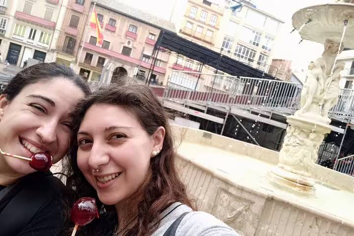 Couple selfie by a Malaga fountain on a self-guided scavenger hunt tour, discovering city sights and squares