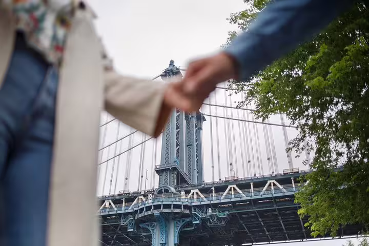 Couple holding hands near the Manhattan Bridge, perfect moment on a private Brooklyn and DUMBO photo tour
