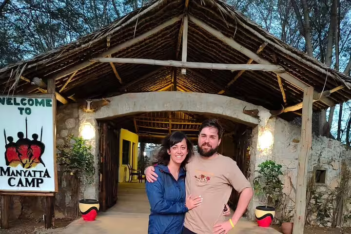 Couple at Manyatta Camp entrance, highlighting cozy accommodations for the Hell's Gate and Nakuru private safari tour.