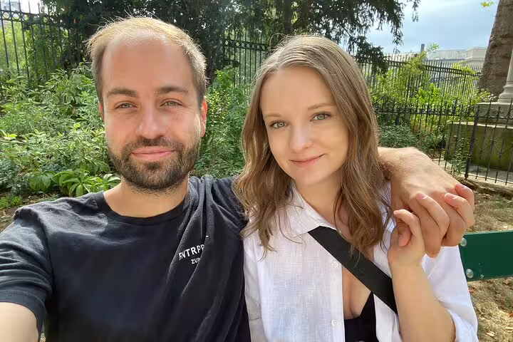 Couple relaxing in a Paris park during a Marais District scavenger hunt and self-guided walking tour