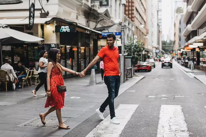 Couple holding hands crossing a Melbourne CBD street on a private tour with personal travel photographer