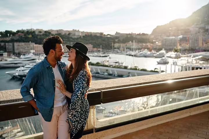 Smiling couple embracing with a scenic backdrop of yachts and Nice harbor on a personalized travel photo tour.