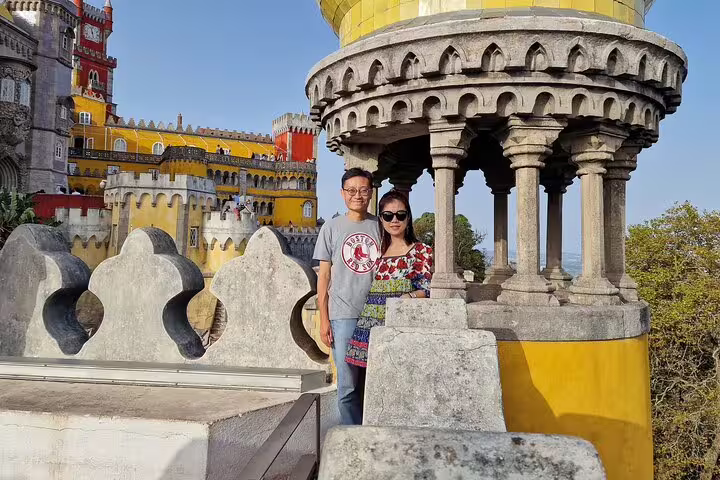 Couple enjoying panoramic views at the colorful Pena Palace during Sintra, Roca, and Cascais full-day private tour.