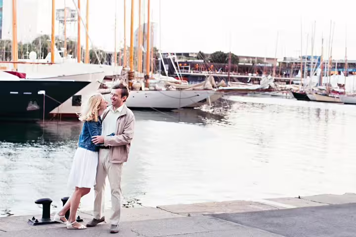 Couple posing by Port Vell marina yachts in Barcelona on a private travel photographer walking tour