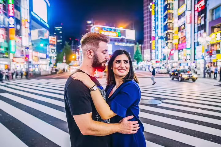 Couple portrait at Shibuya Crossing at night with neon lights, captured on a private Tokyo vacation photo tour
