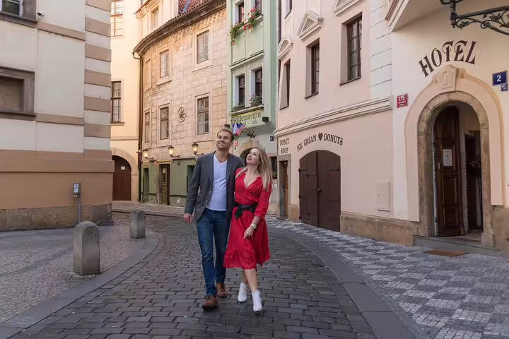 Couple strolling through charming cobblestone streets of Prague during a private photoshoot experience.
