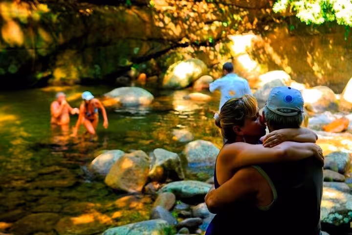 Couple enjoying a serene moment by a rocky stream on a private jeep tour in Paraty, capturing nature's tranquility.
