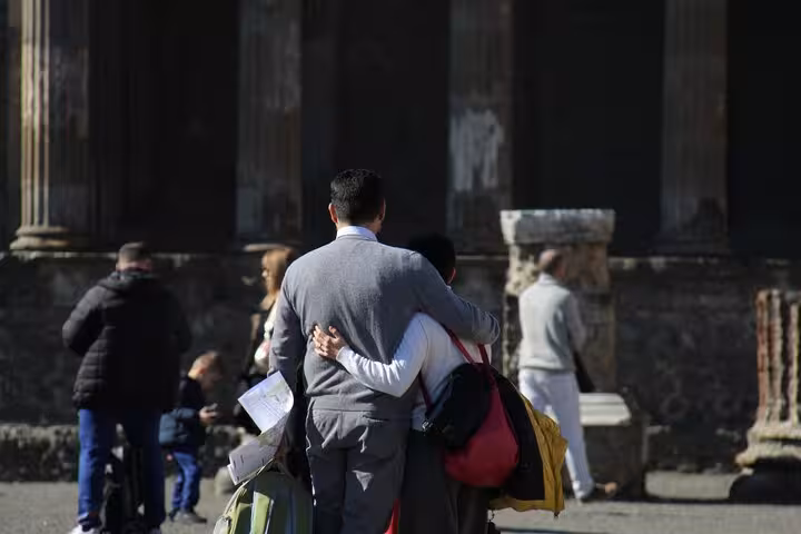 Couple embracing while exploring ancient ruins during a private Pompeii tour from Rome.