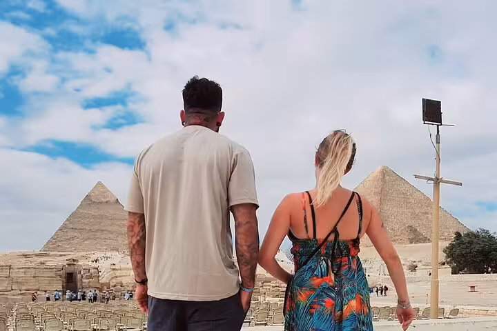 Couple holding hands as they walk towards the majestic pyramids during a private Giza tour.