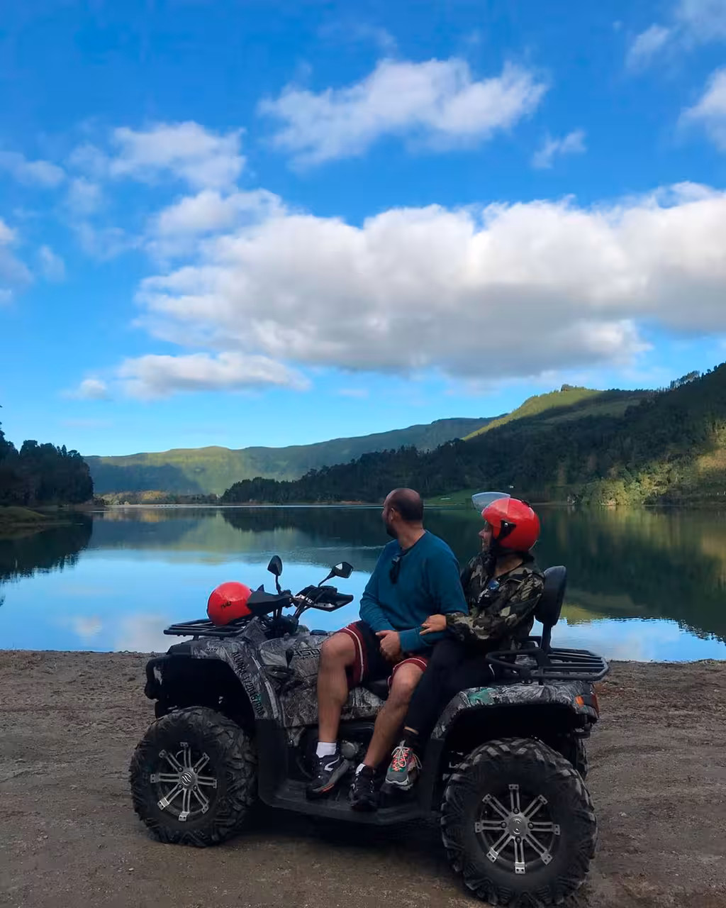 Couple on quad ATV by calm crater lake on coast-to-coast off-road excursion, guided ride with lunch stop