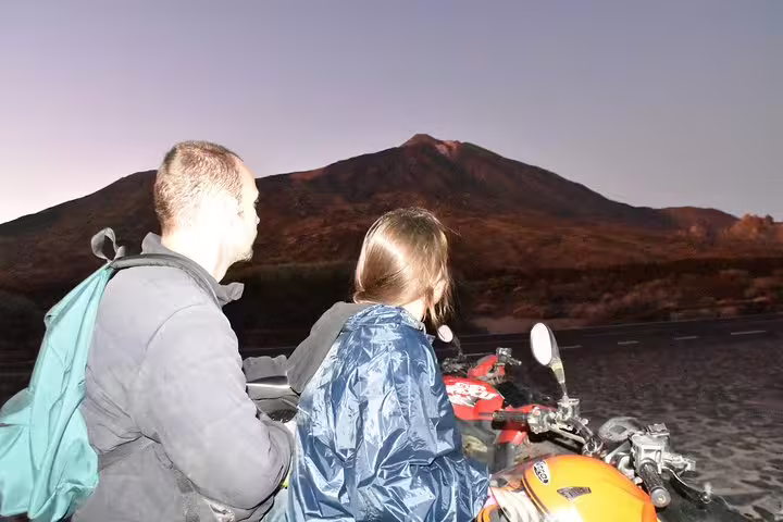 Couple on a quad bike gazing at Mount Teide during a sunset tour in Tenerife.