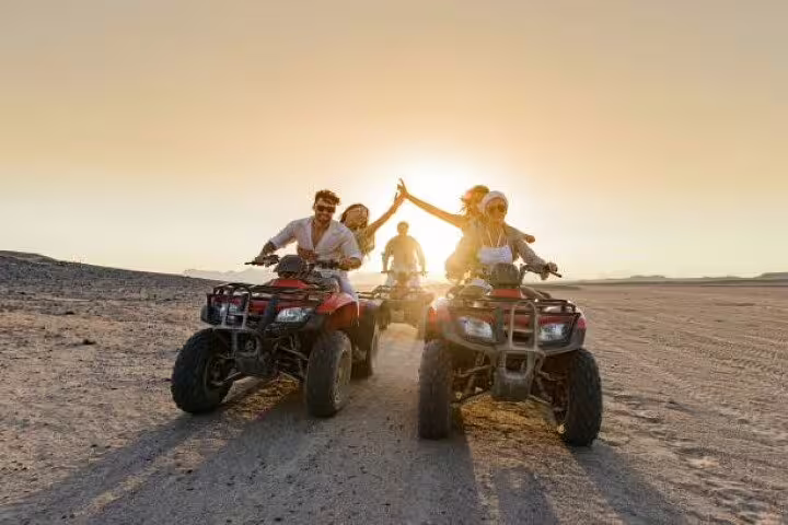 Couple riding quad bikes at sunset on a private ATV safari adventure tour from Sharm El Sheikh desert