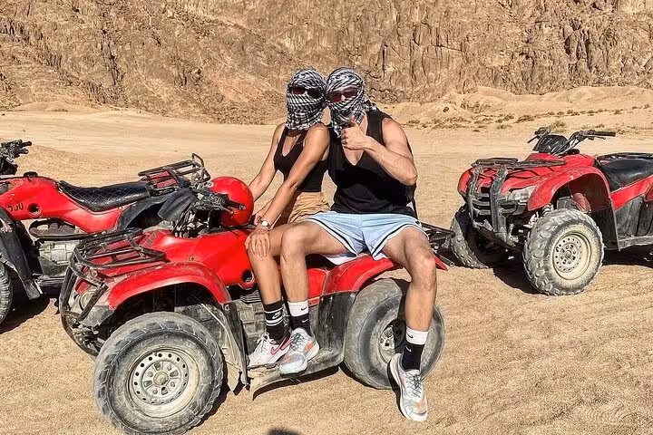 Couple on red quad bikes in Sinai desert, Sharm El Sheikh shared safari ATV adventure tour