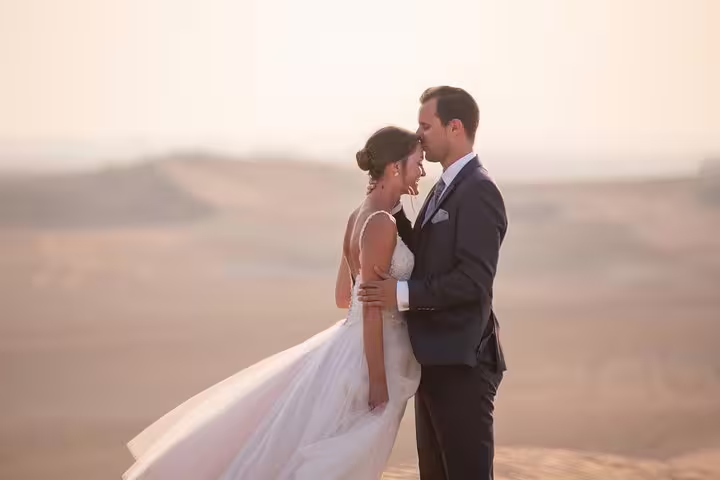 Couple romantic Dubai desert photo shoot at sunset with private travel photographer tour and styling guidance