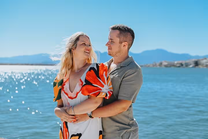 Happy couple embracing by the sparkling sea in Elounda, capturing romantic moments during a private photoshoot.