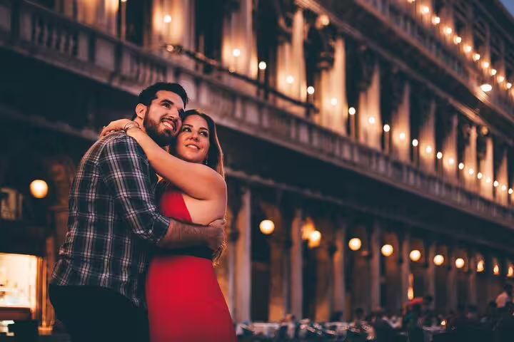 Couple hugging in Venice at dusk, romantic private gondola ride photo shoot with professional photographer