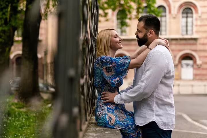 Couple sharing a moment against a wrought iron fence in Verona, ideal for capturing candid photoshoot memories.