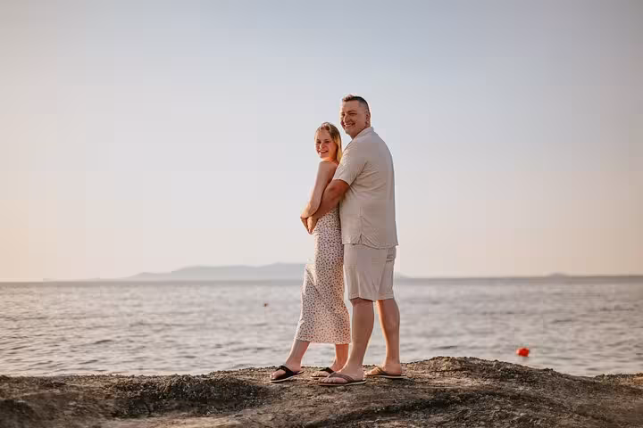 Happy couple posing by the sea, capturing romantic moments on a Gouves private photoshoot.
